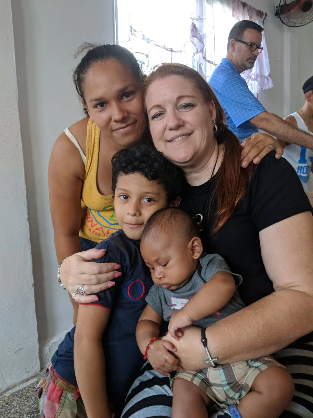 Loring holding a baby beside a Honduran mother and her son.