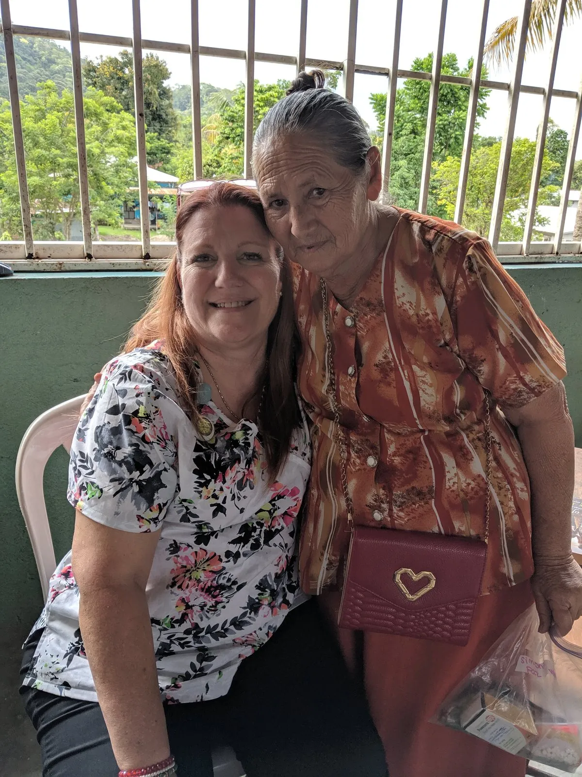 Loring beside an elderly Honduran woman at a window.