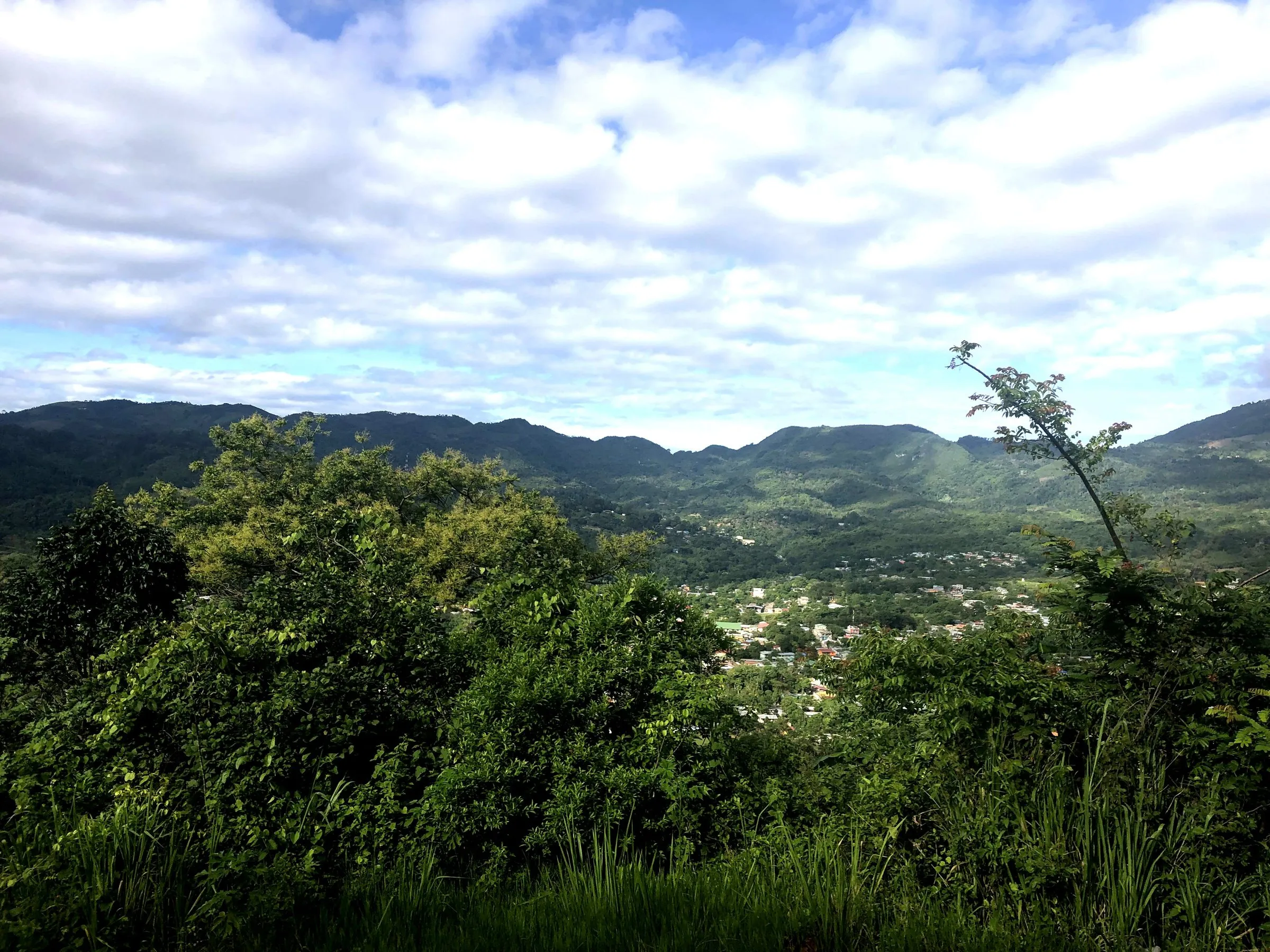 Green hills and a valley town under a wide sky in Honduras.